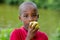 Close up of funny little boy eating an apple