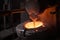 close-up of a furnace, with molten metal being poured into molds