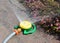 A close-up on a gardener`s supply, plastic circular lawn sprinkler watering the flowers on a flowerbed