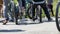 Close-up of a gathering of young people on bicycles and scooters, view of the legs