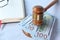 Close up of gavel, cash and open book on white desk