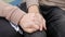 Close-up of gay hands, male couple stroking and holding hands on the swing, romantic homosexual relationship