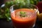 close-up of gazpacho, with droplets of juice and herbs visible