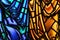 Close up, generic details of stained glass in vibrant blue and orange tones