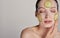 Close up gentle sophisticated calm girl in a moisturizing mask with a fresh cucumber on the face