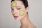 Close up gentle sophisticated girl in a moisturizing mask with a fresh cucumber on the face