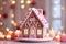 Close up of gingerbread house with pastel pink decorating, lights blurred backdrop. Festive and cozy Christmas background