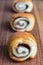 Close-up of gingerbread rolls, the first focused, the others in bokeh on wooden table