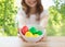 Close up of girl with bowl of colored easter eggs