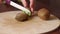 Close-up girl cuts kiwi on a wooden Board.