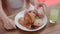 Close-up of Girl Eating Fresh Bun Sitting in Outdoor Cafe, Breakfast in Hotel