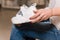 Close-up of girl hold white casual sneakers