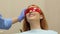 Close-up of a girl lies in a dental chair in safety glasses.