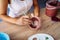 Close-up of girl painting clay mug. Woman coloring pottery in workshop with a paintbrush. Painter in white tanktop