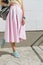 Close-up of girl in pink skirt, yellow shirt and with a backpack