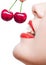 Close up of girl with red lips eating two berries