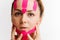 Close-up of a girl`s face with cosmetological pink anti-wrinkle tape