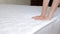 Close up of a girl's hand checks the rigidity of a new comfortable orthopedic white mattress for the bed. Female