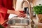 Close-up of a girl& x27;s hands washing vegetables in the kitchen under the faucet. Preparing vegetables for cooking