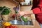 Close-up of a girl& x27;s hands washing vegetables in the kitchen under the faucet. Preparing vegetables for cooking