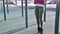 Close-up of girl`s legs on the open area for workout. Woman shakes the press hanging on the horizontal bar