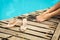 Close-up of a girl`s legs resting near the pool. The girl took off her shoes and relaxes