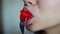 Close up of a girl\'s mouth eating tomato