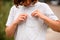 Close-up of girl`s t-shirt pocket in which she puts her wireless headphones