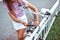 Close-up, a girl in summer in city, puts lock on her bike, protection against theft, bicycle parking in the city. Closes