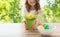 Close up of girl with toy chicken in flowerpot