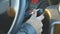 A close-up of a girl turns on the steering-wheel lever wipers. Woman driving a car. Girl`s hand on the switch