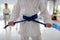 Close up of girl wearing white kimono tying her blue belt