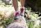 Close up of a girls feet in hicking shoes walking and balancing on a fallen tree trunk