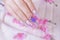 Close up glamorous woman hand manicure with long acrylic extension stiletto style painting sweet ombre pink glitter decorated with