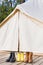 Close-up of glamping bell tent with shoes. Family camping concept