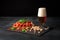 Close-up of a glass of beer. Alcoholic beer with various snacks on a black background. Salty nuts, tasty ham slices