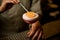 Close-up of glass of cocktail with foam which bartender decorates with orange slice