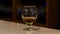 Close up of a glass with cognac, brandy or whisky standing on the bar counter. Stock footage. Strong strong alcoholic