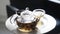 Close up of glass cup with teapot stand on metal tray with hot tea