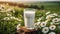 Close-up of glass of fresh milk, green grass and daisies on background. Tasty and healthy beverage