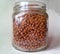 Close-up of a glass jar with dry food. Transparent jar with brown granules.