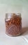 Close-up of a glass jar with dry food. Transparent jar with brown granules.