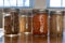 Close up glass jars full of seeds and grains on a sunny kitchen counter top