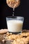 Close-up of glass of milk with cookie and drops of milk, on wooden table with cookies, selective focus, black background
