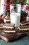 Close up of a glass of milk surrounded by Nanaimo bars for Christmas.