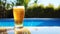 Close up of a glass pint of cold beer near the pool