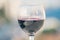 Close up of glass of red wine against the background of blurred town with bokeh