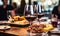 Close-up of a glass of red wine on a bar table with blurred people and charcuterie board in the background at a cozy wine tasting