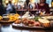 Close-up of a glass of red wine on a bar table with blurred people and charcuterie board in the background at a cozy wine tasting