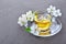 Close-up glass teacup with green tea and spring flowers